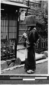 Portrait of a komuso playing a shakuhachi outside a house, Japan, ca. 1937