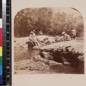 Group of indigenous men with missionary resting on river bank, Madagascar, ca. 1865-1885