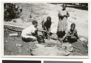 Children washing dishes at a water pipe, South Africa