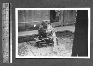 Tibetan woman making something with straw, Tibet, China, ca.1941