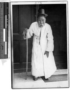 Portrait of an elderly Korean man holding a walking stick, Korea, ca. 1920-1940