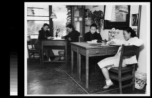 Four students at study tables in their dormitory room, Women's College, Yenching University, Beijing, China, 1941