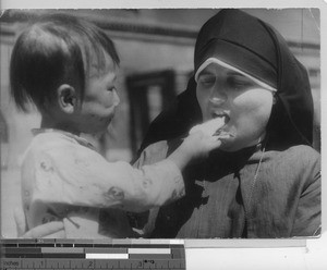 Maryknoll Sister with an orphan at Fushun, China, 1937