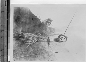 Man standing near boat, Leshan, Sichuan, China, ca.1915-1925