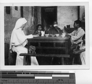 Maryknoll Sister shares the dinner table with a family at Guangdong, China, 1948