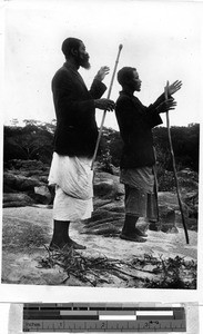 Two men with staffs praying with outstretched hands, Africa, 1933