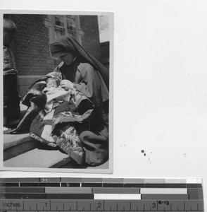 Sister Paula cradles a baby at Fushun, China, 1934