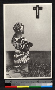 Young woman kneeling before crucifix, Congo, ca.1920-1940