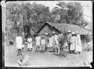 Group of Africans and Europeans in front of a mud house, Arusha, Tanzania, 1927
