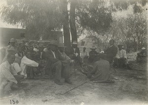 People gathered under eucalyptus, waiting for the Sunday Service