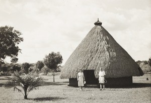 Missionaries outside conical hut, Nigeria, ca. 1938