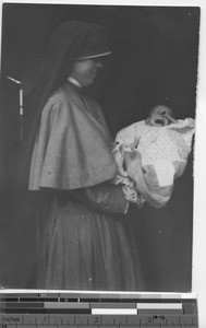 Maryknoll sister with a baby at Fushun, China, 1934