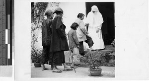 Maryknoll Sister helps woman, Tsungkeou, Kaying, China, ca. 1940