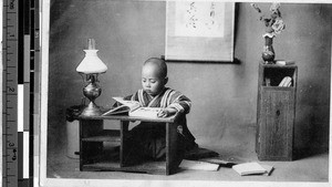 Boy sitting reading, Osaka, Japan, ca. 1920-1940