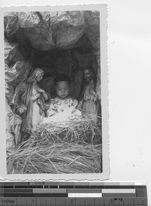 A child views the Christmas crib at the convent at Luoding, China, 1933