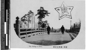 Two people walking across a bridge, Japan, ca. 1920-1940