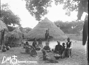 African people in front of a hut, Antioka, Mozambique, ca. 1896-1911