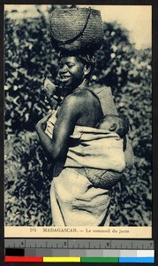 Young woman carrying infant and basket, Madagascar, ca.1920-1940