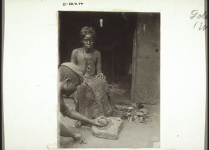 Female diviner and medicine man. The latter is preparing medicine