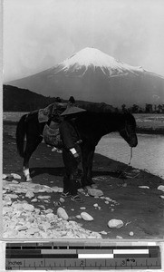 Japanese man and his horse standing on a riverbank, Japan, ca. 1920-1940