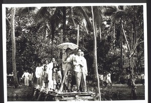 A Dajak bride on the way to church. Pangkoh. The bridesmaid holds the umbrella