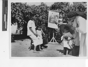 Sr. Dolorosa with assisting a child at Jiangmen, China, 1950