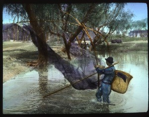 Fisherman drawing in nets by the shore, China, ca.1917-1923