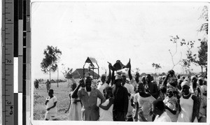 Large crowd of people walking holding rhinoceros horns, Africa, ca. 1920-1940