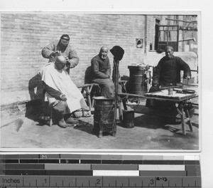 A traveling barber in Fushun, China, 1937