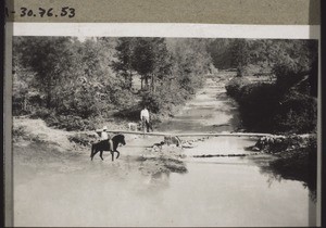 Primitive Brücke. Durchqueren des Flusses zu Pferd