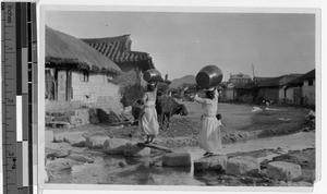 Korean women crossing stream carrying empty waterjars, Korea, ca. 1920-1940