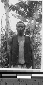 Close-up view of a man standing in front of several trees, Africa, 1947