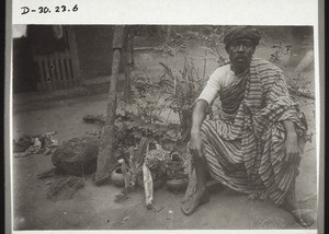 A candidate for baptism, a former fetish priest, sitting on his fetishes