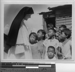 A Maryknoll Sister speaks with children at Meixien, China, 1940