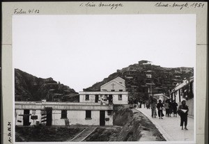 Im Hintergrund Flüchtlingquartiere. Im Vordergrund Kirchlein u. Schule