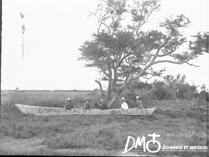 Group of European men in a pirogue on dry land, South Africa, ca. 1896-1911