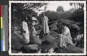 Clergy pose on rocks on the Uele River, Congo, ca.1920-1949