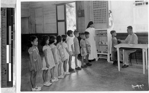 Sr. Claver Sanglap, MM, with children in Catholic school infirmary, Lucena, Philippines, 1946