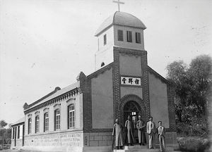 Den nye kirke i Yahutsui fra 1937. Ifølge den oprindelige billedtekst er de personer, der står foran kirkedøren, "en af Port Arthurs bedste præster og den gamle evangelist" sammen med et par menighedsråds medlemmer