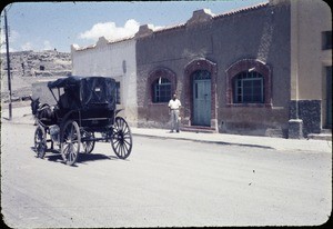 Horse and buggy with church and preacher's house