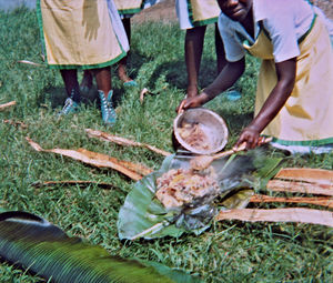 Nordveststiftet,Tanzania, 1984. Her vises forberedelser til en picnic på Ntoma Husholdningsskole. Den færdige mad pakkes ind i bananpalmeblade. Det kan være kogte bananer, bønner, grøntsager osv. Man lader bananbladene gå gennem ilden, så de er renset inden anvendelse