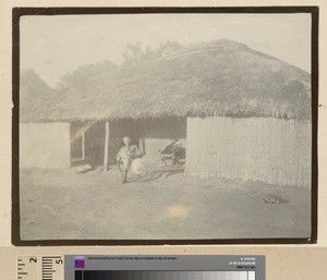 Man seated outside a house, Mozambique, ca.1925