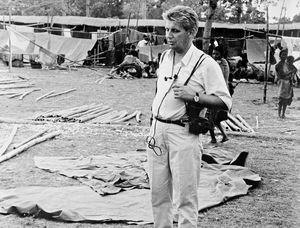 Fra flygtningelejr på en skoleplads i Cooch Behar, West Bengal, Nordindien. Arkitekt Niels Anton Dam ses her i flygtningelejren, midlertidigt opstillet af forhåndenværende materialer og presenninger. Skolens lokaler og redskabsrum er også fyldt med flygtninge. Skolen var lukket over 30 dage, da flygtningestrømmen kulminerede i maj-juni 1971