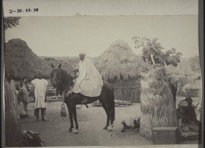 Haussa chief on horse-back, the horse wearing charms; Haussa huts, Haussa compound