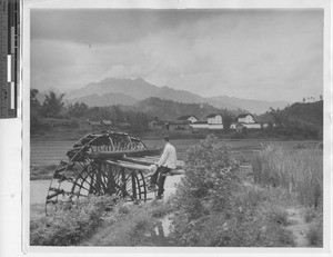 A man working the water mill at the mission at Pingnan, China, 1947