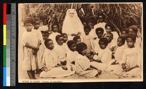 Missionary sister seated with numerous small children, Mozambique, ca.1920-1940