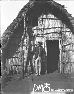 African man standing in front of a chapel, Catembe, Mozambique, ca. 1896-1911