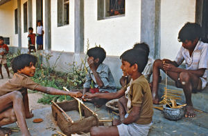 36.- Tamil Nadu, Indien, 1988-89. "Med 80 elever i klassen" - En dansk lærer i Arcot skoleprojekt fortæller: Her er en gruppe i fuld gang med at lave en meget flot tagrejsning. Hytten blev bygget i målestoksforholdet 1:15