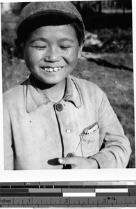 Smiling Japanese boy wearing a baseball hat, Japan, ca. 1949