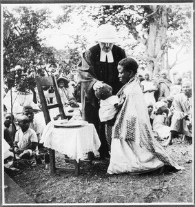 Missionary Guth baptising a baby, Tanzania, 1935